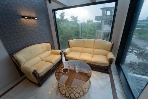 two chairs and a table in a room with a window at Royal Cabana Lonavla - 6BHK Luxury Villa with Heated pool and Turf in Lonavala