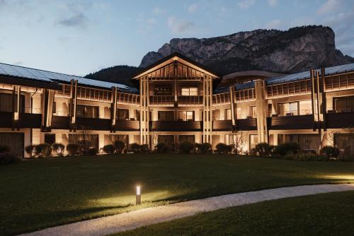 a large building with a grass field in front of it at Granbaita Dolomites in Selva di Val Gardena