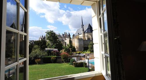 an open window with a view of a castle at Le Relais du Bellay in Montreuil-Bellay