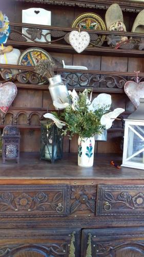 a wooden dresser with a vase of flowers on it at Bim Cathele in Burbach