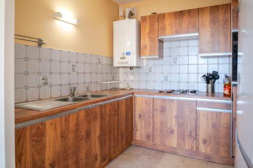 une cuisine avec des armoires en bois et un évier dans l'établissement Appartement face mer - quartier des Présidents - 5 personnes, à Les Sables-dʼOlonne