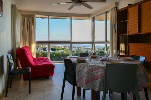 une salle à manger avec une table et une chaise rouge dans l'établissement Appartement face mer - quartier des Présidents - 5 personnes, à Les Sables-dʼOlonne