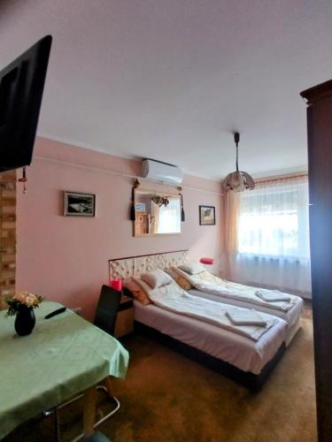a bedroom with two beds and a tv in it at Bundik Vendégház in Berettyóújfalu