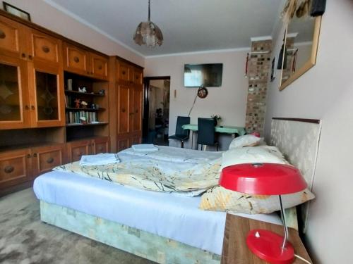 a bedroom with a bed and a red lamp at Bundik Vendégház in Berettyóújfalu