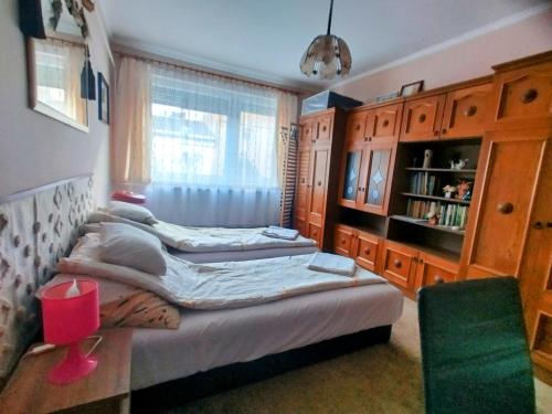 a bedroom with two beds and a window at Bundik Vendégház in Berettyóújfalu