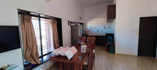 ein Wohnzimmer mit Tisch und großem Fenster in der Unterkunft Eagle Eye Resort in Mahabaleshwar