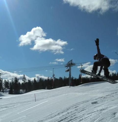 a person on skis doing a jump in the snow at Taigaschool Eco Hotel in Virrankylä