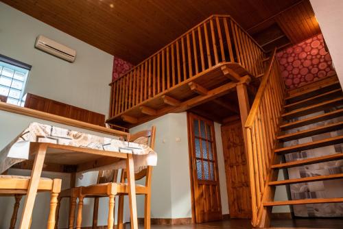 two wooden bunk beds in a room with a staircase at Gesztenye Apartman in Makó