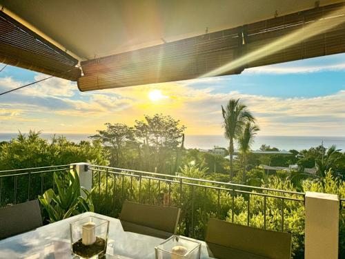 a table on a balcony with a view of the ocean at Seaview Sunset Apartment 2 in Rivière Noire