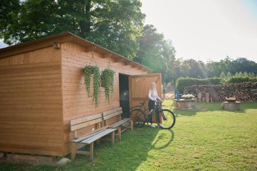 a woman standing next to a bike next to a shed at Penzion U Nováků in Kožlí u Orlíka