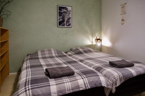 a bed in a bedroom with two towels on it at Taigaschool Eco Hotel in Virrankylä