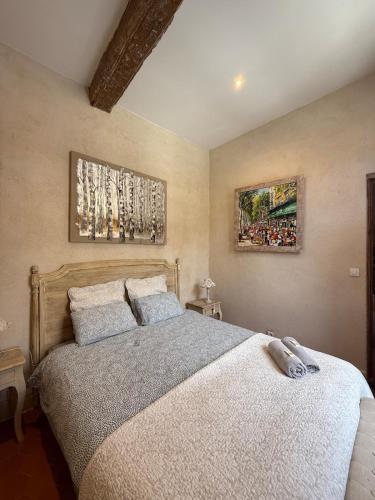 une chambre avec un lit et deux tableaux au mur dans l'établissement Bel appartement aixois dans le centre historique, à Aix-en-Provence