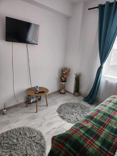 a room with a bed and a table and a tv at ARP LUXURY Apartments in Ploieşti