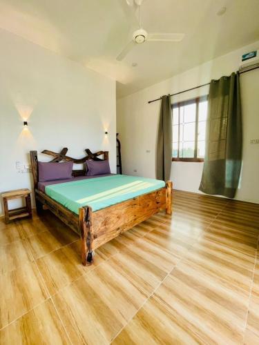 a bedroom with a large wooden bed in a room at Swahili lodge nungwi in Kinyasini