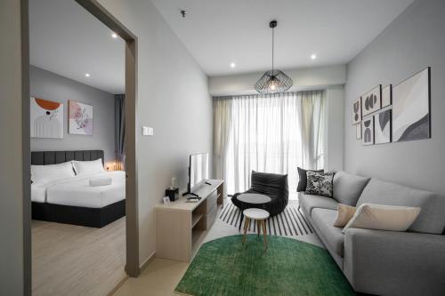 a living room with a couch and a bed at Iconic Regency Service Residences, managed by Iconic Hotel in Bayan Lepas