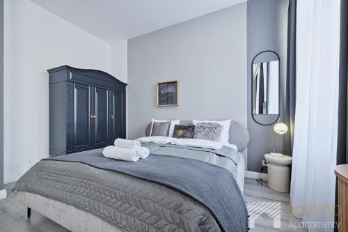 a bedroom with a large bed with towels on it at Kolorova Apart by LookAp - darmowy parking w centrum Łodzi! in Łódź
