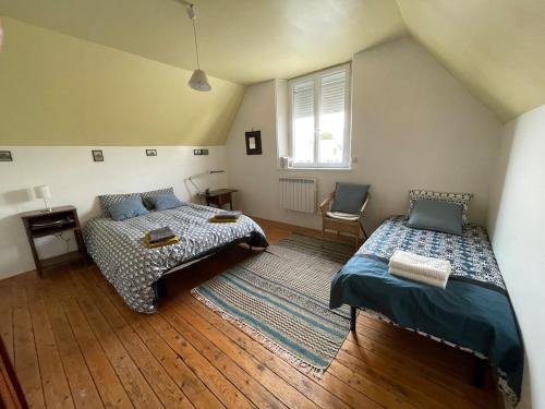 une chambre avec deux lits et une fenêtre dans l'établissement Maison TOTORO, à Heugueville-sur-Sienne