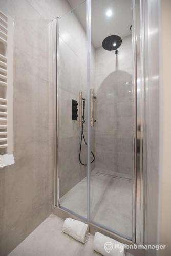 une douche avec une porte vitrée dans une salle de bain dans l'établissement CIA - Flat on rue La Fayette, à Paris
