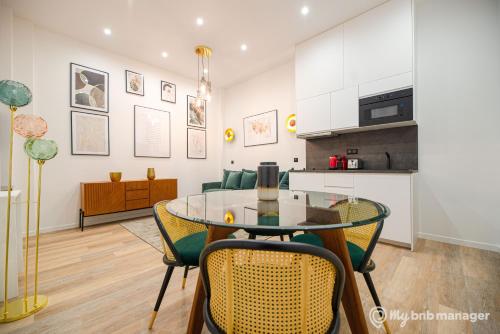une cuisine et une salle à manger avec une table et des chaises en verre dans l'établissement CIA - Flat on rue La Fayette, à Paris