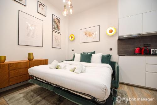 une chambre avec un grand lit dans une pièce dans l'établissement CIA - Flat on rue La Fayette, à Paris
