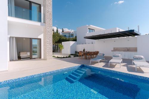 a villa with a swimming pool and a house at Akamas Luxury Villas in Paphos City