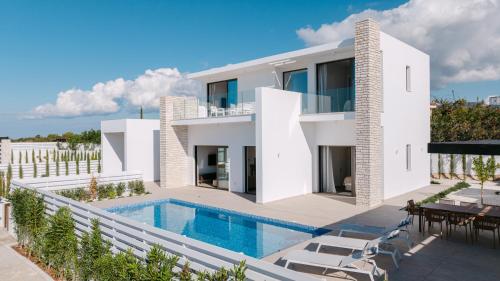 a large white villa with a swimming pool at Akamas Luxury Villas in Paphos