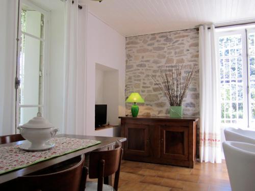 - un salon avec une table, des chaises et une télévision dans l'établissement La TONNELLE, à Gailhan