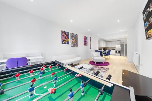 a living room with a pool table with toy people on it at Purple Reignz - 3BR - close to LDN in Brent Station