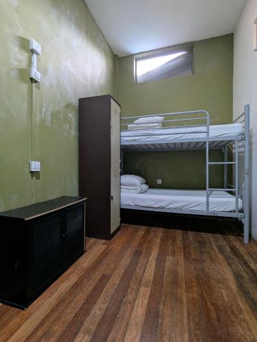 a room with two bunk beds and a wooden floor at The Manor by Mingle - FREE Breakfast with Poolside Access in Kuala Lumpur