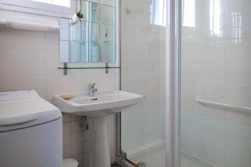 une salle de bain blanche avec un lavabo et une douche dans l'établissement Charmant appartement avec jardin privatif - quartier Saint Michel - 5 personnes, à Les Sables-dʼOlonne