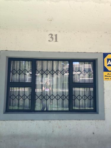 una ventana en un edificio con el número en Nyumbani, en Kempton Park