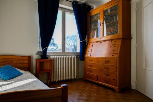 - une chambre avec une grande commode en bois et une fenêtre dans l'établissement Charmant appartement avec jardin privatif - quartier Saint Michel - 5 personnes, à Les Sables-dʼOlonne