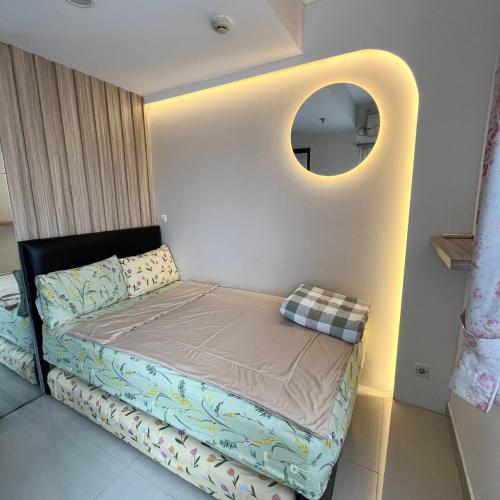 a small bed in a room with a mirror at Minimalist 2BR @Sudirman Suites Apartment in Bandung