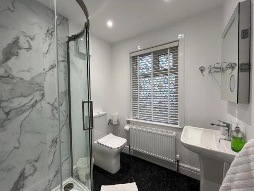 a bathroom with a shower and a toilet and a sink at Luxury Beds Parking 2 Bathrooms 3 Large Bedrooms Nice Area in Morecambe