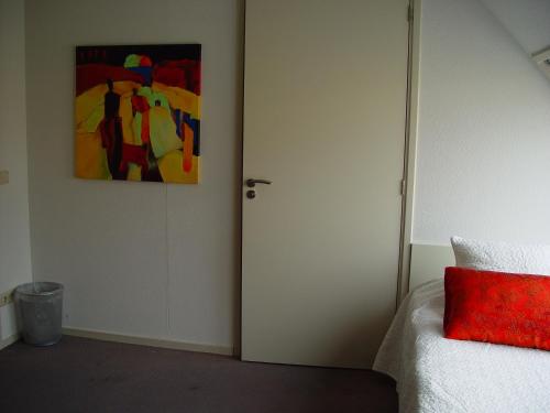 a bedroom with a door and a painting on the wall at Piaam State in Piaam