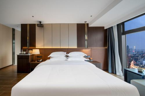 Postel nebo postele na pokoji v ubytování Chongqing Junsheng Yunduan Riverview Hotel