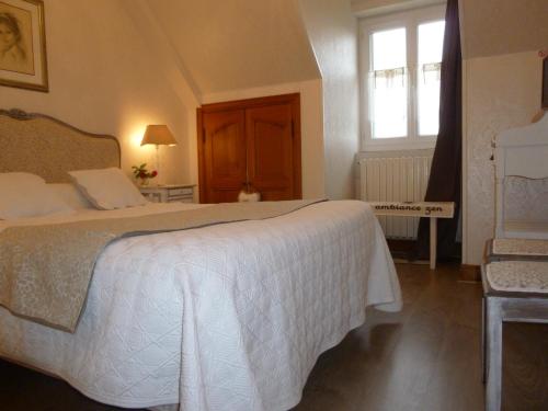 - une chambre avec un lit blanc et une fenêtre dans l'établissement Chambres d'Hôtes Le Clos des Senteurs, à Malemort-sur-Corrèze