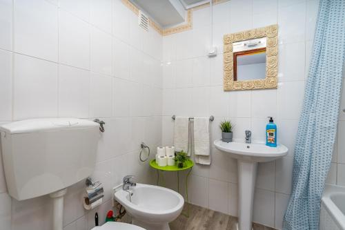 een badkamer met een toilet, een wastafel en een spiegel bij Sun & Beach Alvor in Alvor
