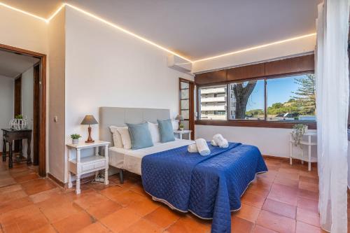 een slaapkamer met een bed, een bank en een raam bij Sun & Beach Alvor in Alvor