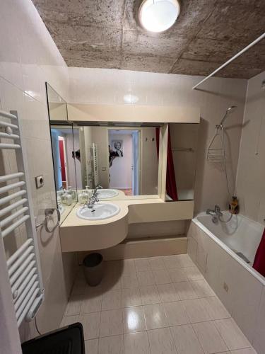 une salle de bain avec un lavabo, une baignoire et un miroir dans l'établissement Spacious and bright apartment 2min from Paris, à Saint-Mandé