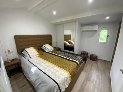 une chambre avec un grand lit et un miroir dans l'établissement Villa Lagon, à Villeneuve-Loubet