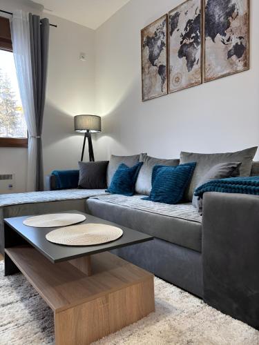 a living room with a couch and a coffee table at Tanasković Home Zlatibor in Zlatibor