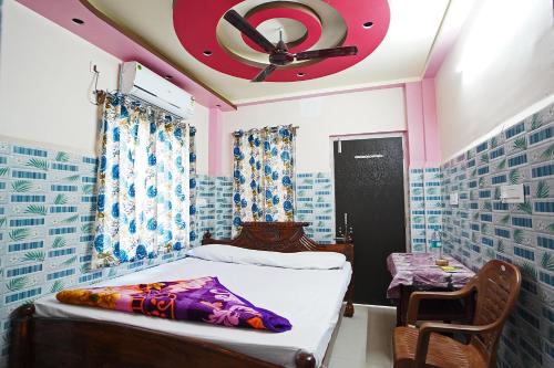a bedroom with a bed and a ceiling fan at Gouranga Guest House Mayapur ISKCON 300 MTS in mayapur