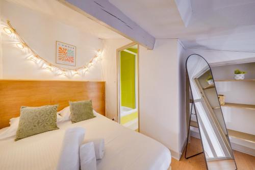 - une chambre avec un lit blanc et une échelle dans l'établissement L'Ô en Couleur - Au coeur de Bordeaux, à Bordeaux