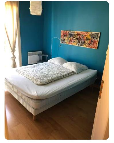 un lit dans une chambre avec un mur bleu dans l'établissement Fitis ! 6 person villa with 1 pool on a residence, à Castellane