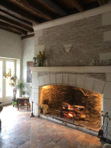 - une cheminée en pierre dans le salon avec cheminée dans l'établissement Gîte de charme - La Boursicauderie, à Le Grand Chaloy