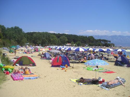 a large group of people on a beach with umbrellas at Room in Lopar with Balcony, WIFI 4620-94 in Lopar
