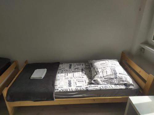a bed with a comforter and a pillow on it at Lake House Hostel in Szczecin