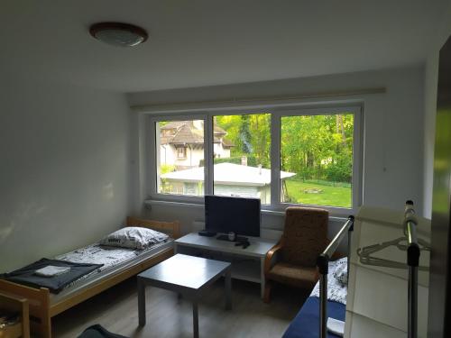 a room with a desk with a computer and a window at Lake House Hostel in Szczecin