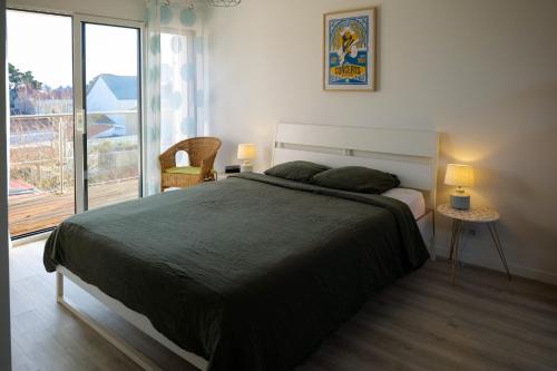 une chambre avec un grand lit et un balcon dans l'établissement L'échappée sablaise - maison proche gare - 6 personnes, à Les Sables-dʼOlonne